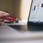 ecommerce kisi holding credit card while shopping online dizustu indicating transactions