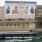 gucci advertising billboard seine river paris passing cruise boat