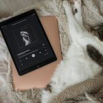 taylor swift cat laying top bed next electronic device dizustu tablet listening