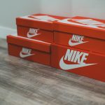 nike red shoe boxes stacked neatly wooden floor indoors