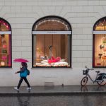 valentino kadin umbrella walks past store rainy rome